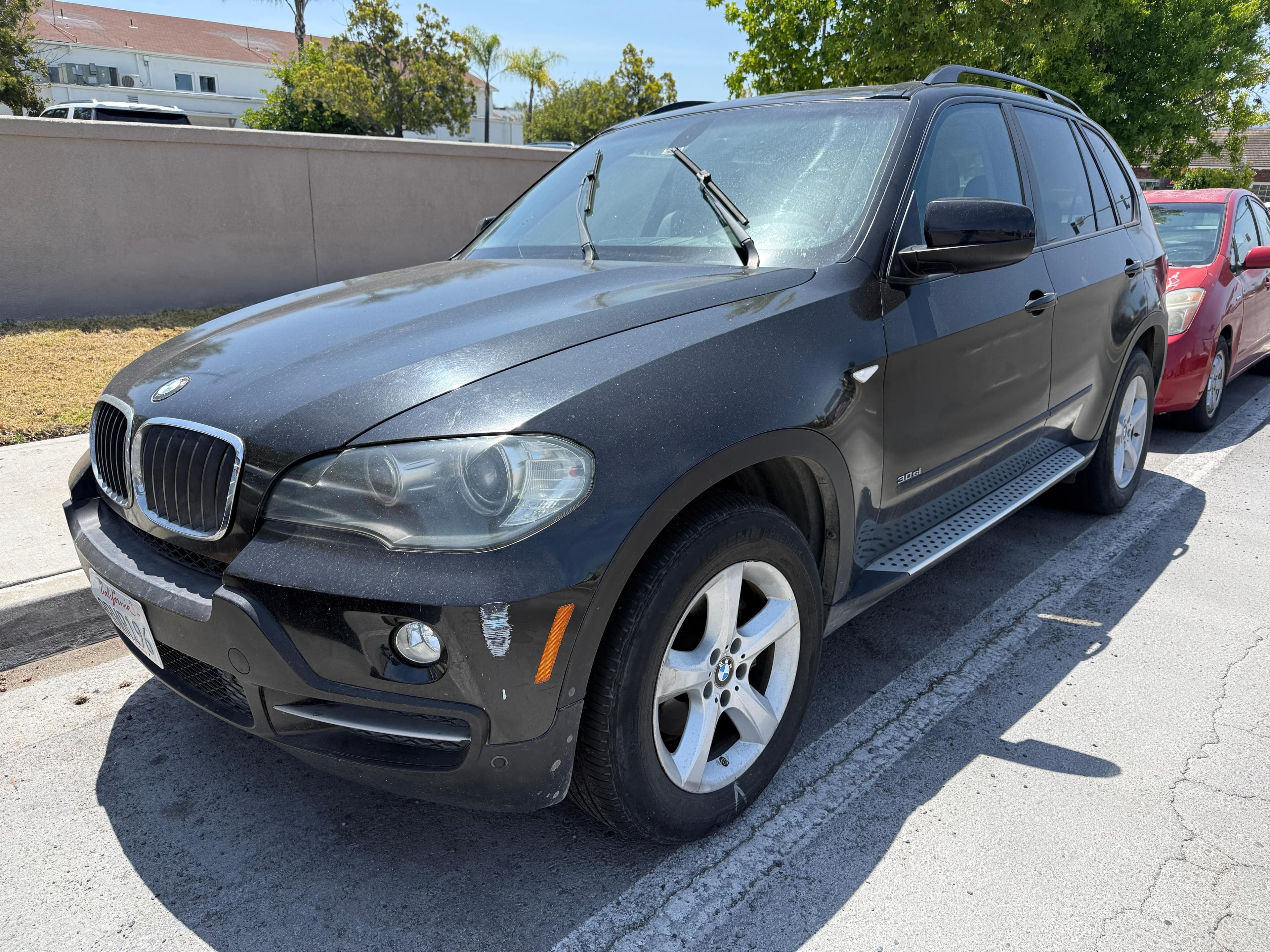 Black BMW X5 SUV with visible front bumper scuffs